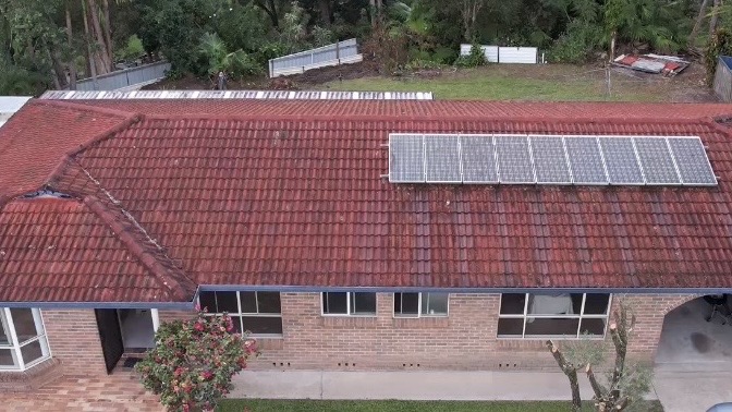 Aerial view of faded red tile roof before restoration