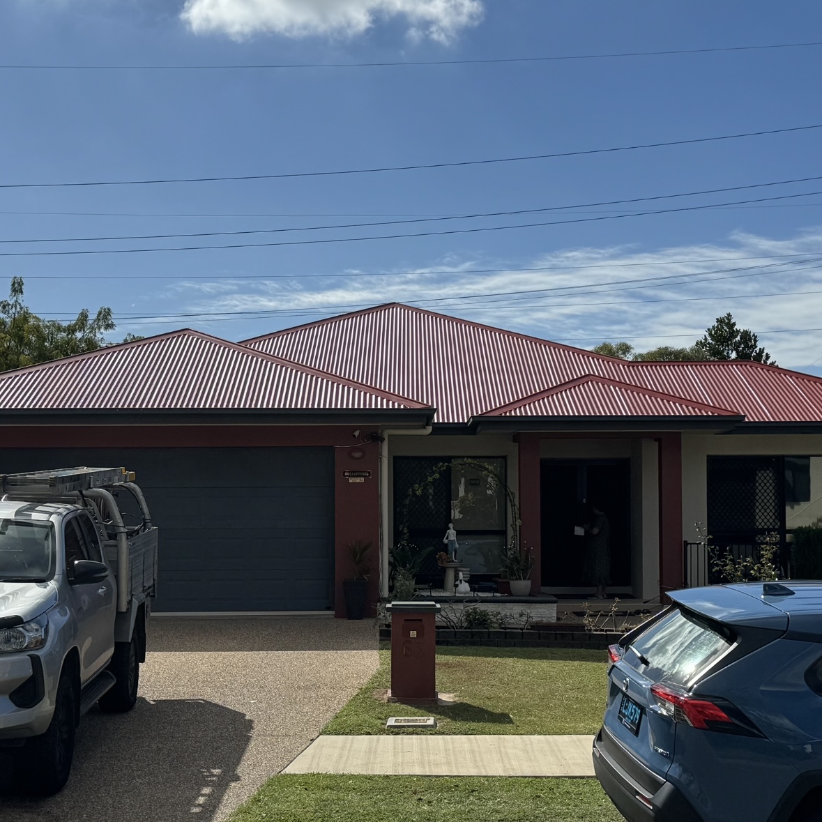 Modern home with deep red Colorbond and company truck