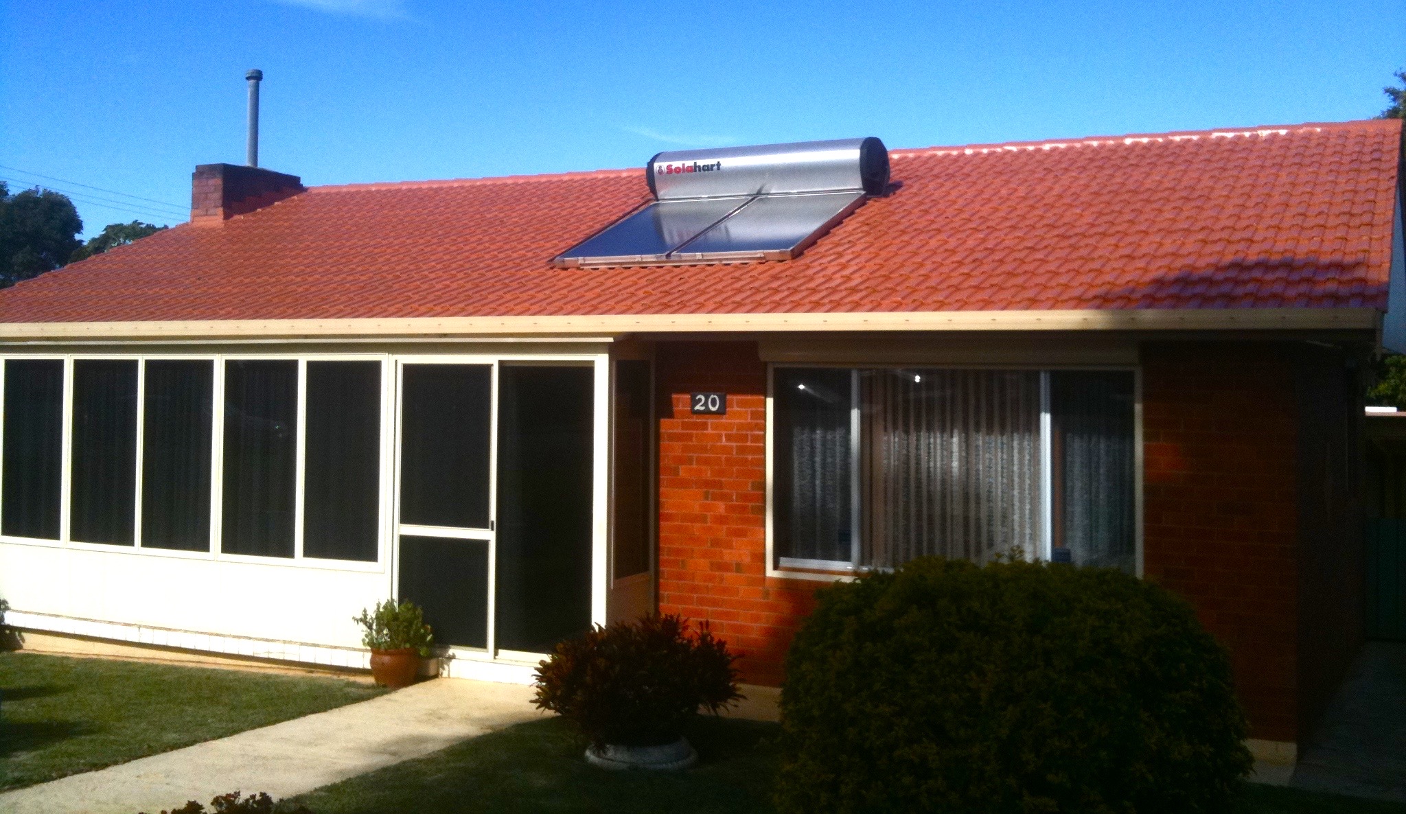 Vibrant red terracotta tile roof with solar panels